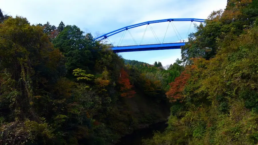 渓谷にかかる橋と、色づきはじめた山
